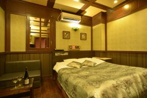 ein Schlafzimmer mit einem Bett und einer Flasche Wein in der Unterkunft Restay Kitakami - Adult Only in Kitakami
