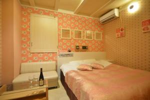sypialnia z 2 łóżkami i butelką wina w obiekcie Restay Kitakami - Adult Only w mieście Kitakami