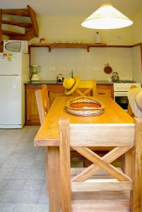 cocina con mesa de madera y nevera en Abvai en Mar de las Pampas