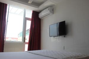a bedroom with a bed with a flat screen tv on the wall at Sai Gon River Hotel in Ho Chi Minh City
