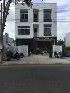 un edificio blanco con motocicletas estacionadas frente a él en Phong Lan Guesthouse, en Chau Doc