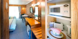 Habitación pequeña con cocina y dormitorio. en Kookaburra Motor Lodge en Halls Gap