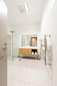 a white bathroom with a tub and a sink at Customs House Hotel in Hobart