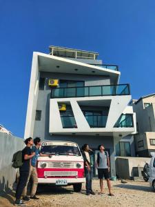 a group of people standing around a car in front of a building at Noah's Ark Homestay in Huxi
