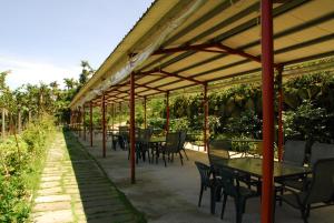 a patio with tables and chairs under a canopy at Ming Zhen Homestay in Gukeng