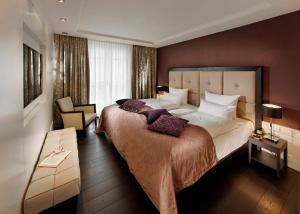 a hotel room with a large bed and a chair at Parkhotel Stuttgart Messe-Airport in Leinfelden-Echterdingen +31 photos