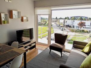 a living room with a large window and a television at Departamento Arrieros in Osorno
