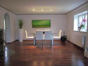 een eetkamer met een tafel en witte stoelen bij Appartement Bergblick II in Faistenau