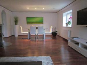 een woonkamer met een tafel en witte stoelen bij Appartement Bergblick II in Faistenau