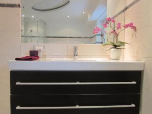 a bathroom with a sink and a vase with flowers at Appartement Bergblick II in Faistenau