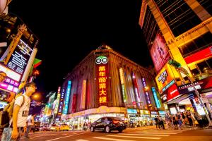 a busy city street at night with neon signs at Hotel 6 - Wannien in Taipei