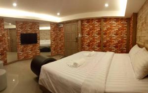 Nava Grand في Ban Talat Rangsit: غرفة نوم عليها سرير وفوط
