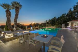 a patio with tables and chairs next to a swimming pool at Aparthotel Adeo in Poreč