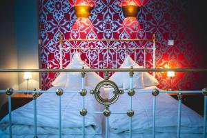 1 dormitorio con 1 cama con pared roja y blanca en Hotel Alexander en Wiesbaden