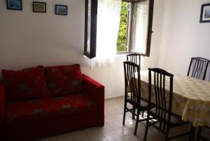 salon ze stołem i czerwoną kanapą w obiekcie Apartment Ana M w Krku