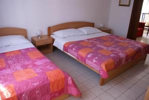 sypialnia z 2 łóżkami i 2 szafkami nocnymi w obiekcie Apartment Ana M w Krku
