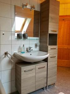 a bathroom with a sink and a mirror at Ferienwohnung Held in Erding