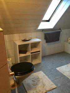 a bathroom with a black toilet and a skylight at Ferienwohnung Held in Erding