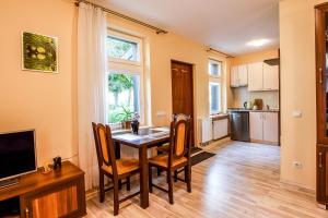 a kitchen and dining room with a table and chairs at Apartamentai Pluke - Biliūno in Palanga