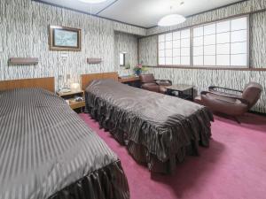 a hotel room with two beds and a waiting room at Riverside Hotel Shoei in Kochi