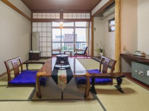 a dining room with a table and chairs and a window at Riverside Hotel Shoei in Kochi