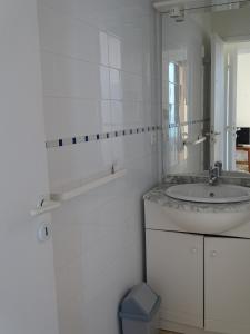 bagno bianco con lavandino e specchio di Résidence Fioravanti Villas Valinco a Tizzano