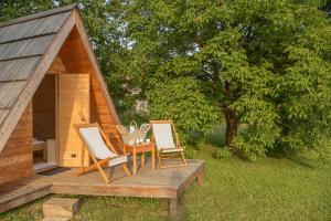 Duas cadeiras e uma mesa num deque ao lado de uma sauna em Glamping Bizjak em Preddvor