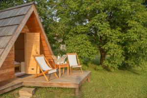 2 sillas y una mesa en una terraza junto a una sauna en Glamping Bizjak, en Preddvor