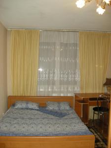 - une chambre avec un lit, un bureau et une fenêtre dans l'établissement Apartament in chirie, à Chişinău