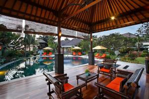 an outdoor patio with a swimming pool with chairs and a pool at Villa L'Orange Bali in Keramas