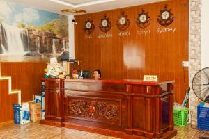 a woman is sitting at a desk in a room at Satraco Royal Hotel in Soc Trang