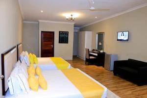 a bedroom with a bed with yellow slippers on it at Blue Waters by Serendib in Senga