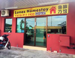 a hotel with a motorcycle parked outside of it at Lunas Homestay in Lunas