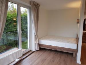 a bedroom with a bed and a large window at Felix Apartment in Vilnius