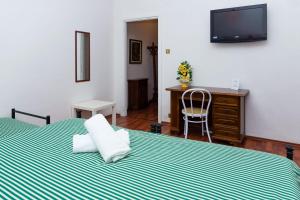 um quarto com uma cama, uma televisão e uma secretária em Affittacamere Orchidea em Ancona