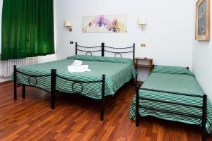 duas camas sentadas uma ao lado da outra num quarto em Affittacamere Orchidea em Ancona