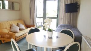 a living room with a table and a couch at Catlins Area Motel in Owaka