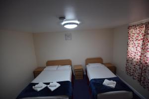 a room with two beds and two lamps at Woodlands Lodge Ilford in Ilford