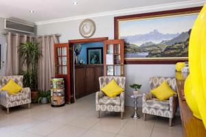 een wachtkamer met stoelen en een schilderij aan de muur bij Waterkloof Guest House in Pretoria