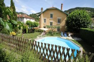 una casa con piscina frente a una valla en La Renardière, en Saint-Sauveur-de-Montagut
