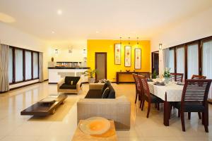 a large living room with a table and a dining room at Villa L'Orange Bali in Keramas