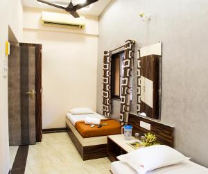 a small room with two beds and a table at Welcome Guest House in Mumbai