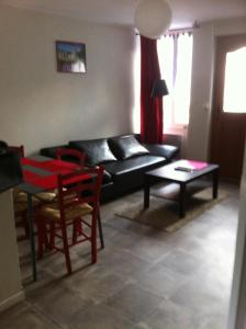 - un salon avec un canapé noir et une table dans l'établissement Melitine, à Saint-Amand-Montrond