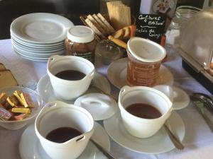 una mesa con dos tazas de café y platos de comida en Logis Hotel Restaurant Le Flamant Rose camargue, en Albaron