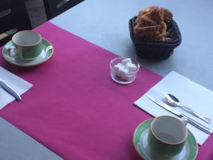 una mesa con dos tazas y una cesta de comida en Logis Hotel Restaurant Le Flamant Rose camargue en Albaron