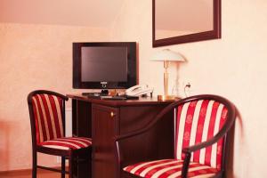 a room with two chairs and a desk with a television at Golden Embankment in Pskov