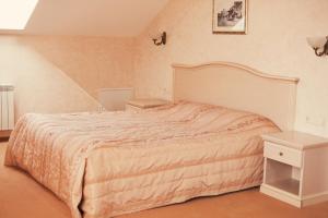 1 dormitorio con 1 cama grande y mesita de noche en Golden Embankment, en Pskov