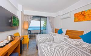 a hotel room with a bedroom with a bed and a table at Floria Beach Hotel in Alanya