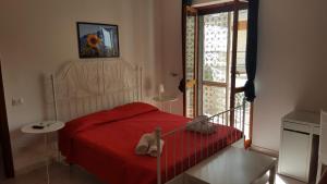 a bedroom with a red bed with shoes on it at Le ginestre in Salerno