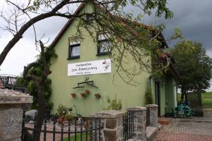 a green house with a sign on the side of it at Landpension Zum Schweizerberg in Neugrimnitz